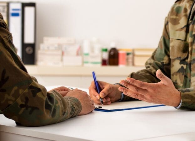 Soldiers filling out forms at medical desk