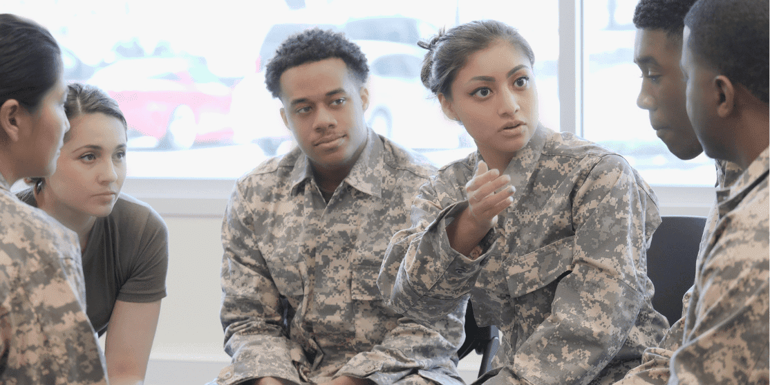 Group of soldiers having a discussion indoors.